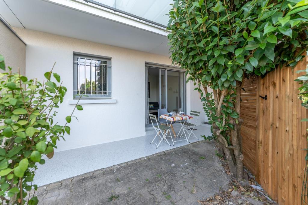 une salle de jardin avec une table et une clôture dans l'établissement Cosy Gallieni - Bel appt avec terrasse à Merignac, à Mérignac