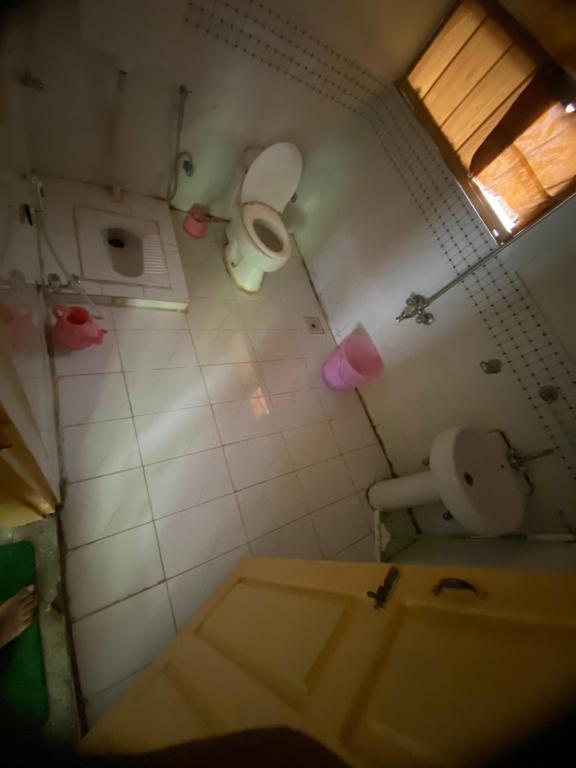 a dirty bathroom with a toilet and a sink at Habib Green Cottage in Upper Neelun