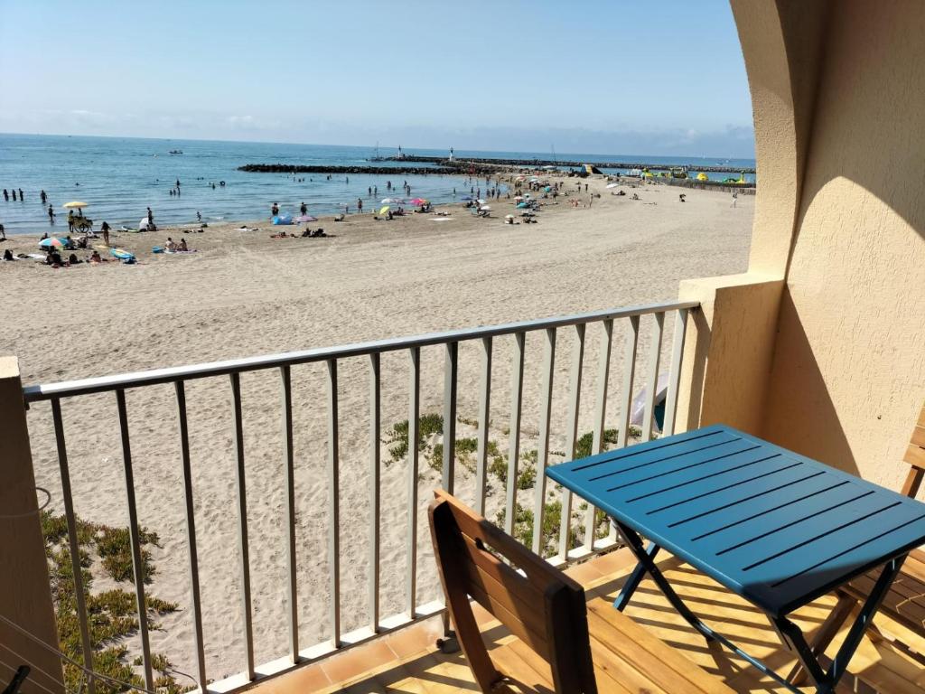 d'une table bleue et de chaises sur un balcon donnant sur la plage. dans l'établissement Carnon Cm, à Carnon-Plage