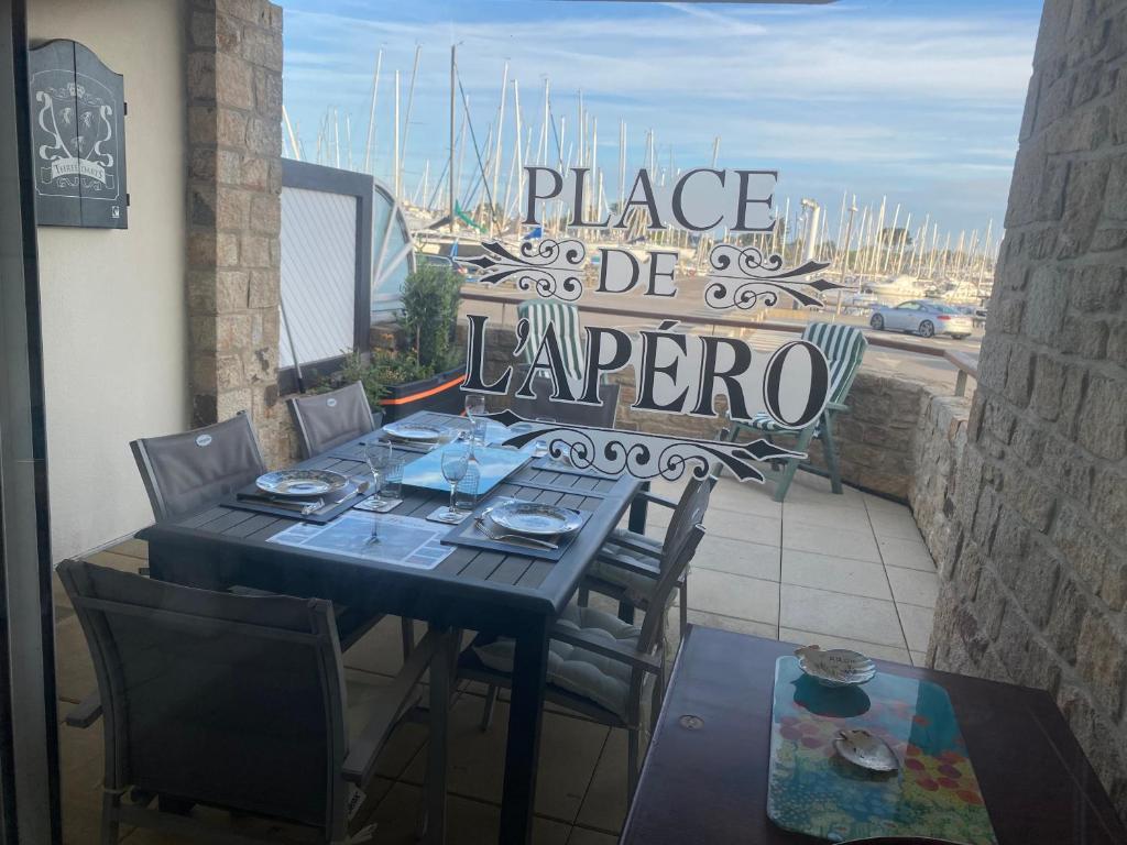 - une table et des chaises sur une terrasse avec vue sur le port dans l'établissement Appartement 3 pièces de 52 m2 face au port du Crouesty avec terrasse de 18 m2 parking privé et wifi gratuit, à Arzon