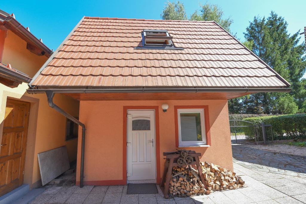 a small orange house with a white door at Central Brežice Chalet & Parking in Brežice