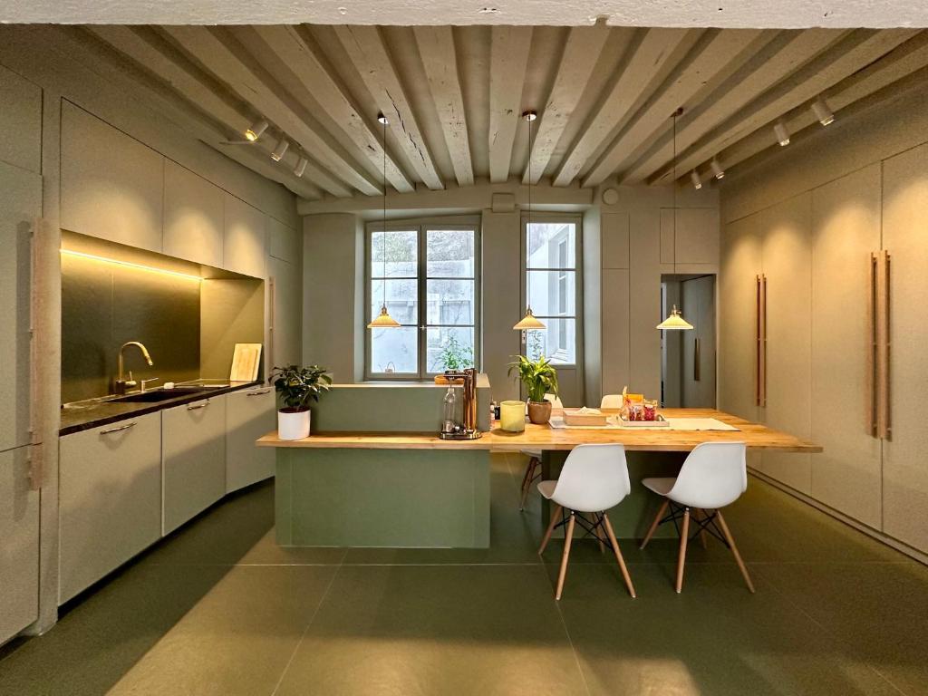 - une cuisine avec une table en bois et des chaises blanches dans l'établissement Paris Marais 8RDL Home - 2 rooms, 2 bathrooms, terrace, à Paris