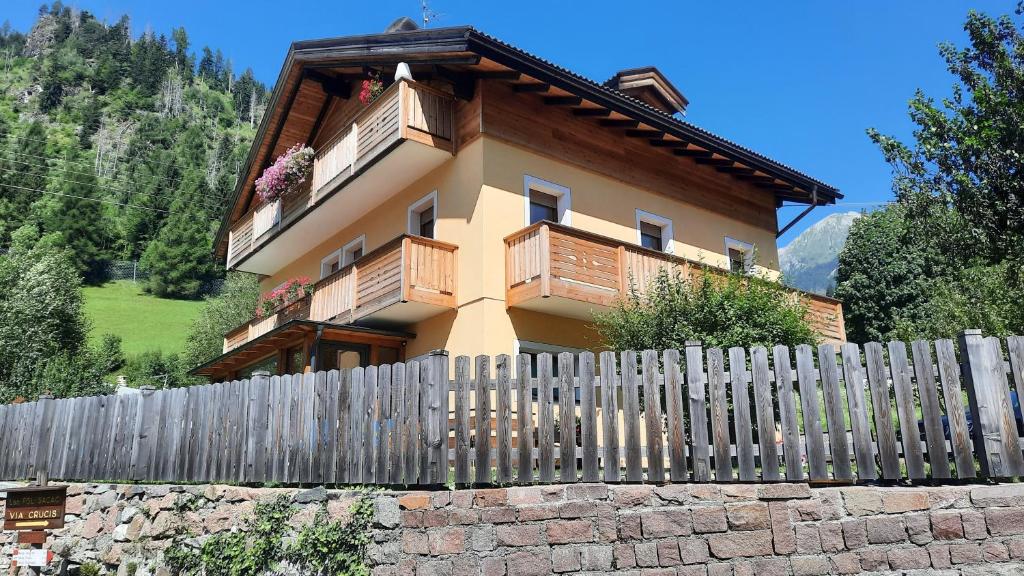 a house with a fence in front of it at B&BeautyFol Dolomites B&B adults only in Predazzo