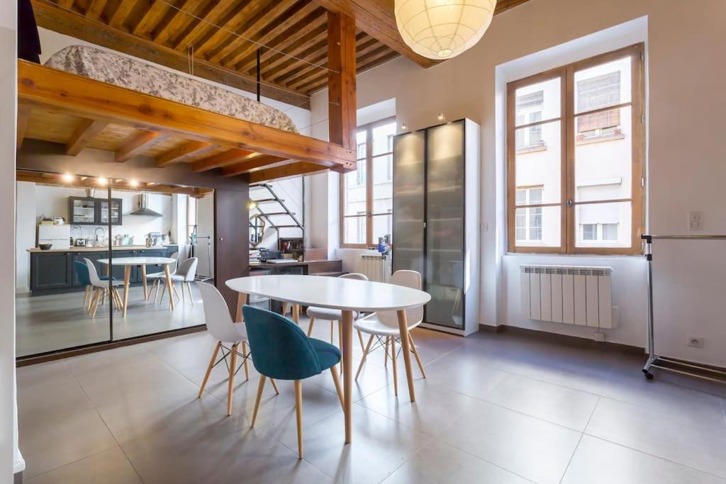 une cuisine et une salle à manger avec une table et des chaises dans l'établissement Loft au coeur de Croix-Rousse - Lyon pour 2 pers, à Lyon