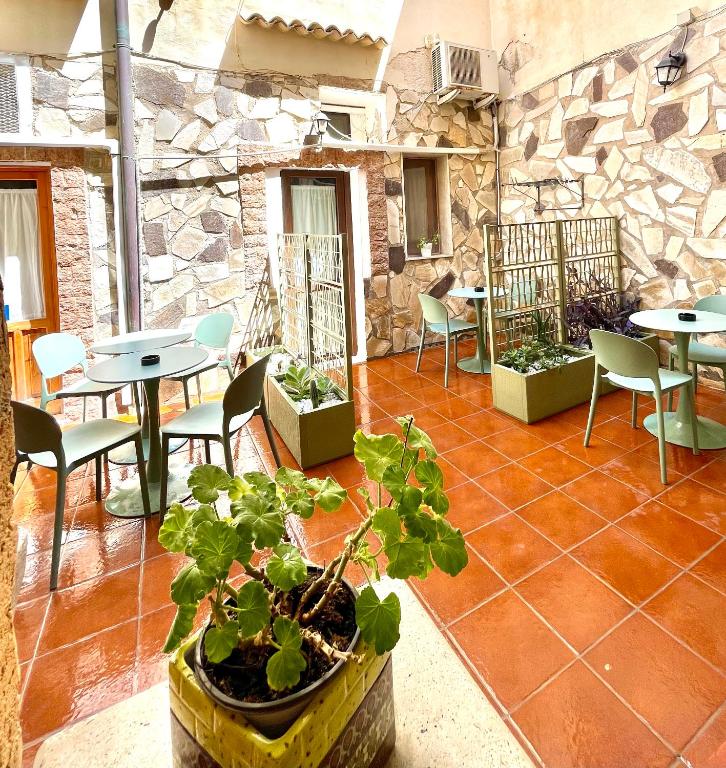 a patio with tables and chairs and a plant at Il Cortiletto di Ortigia in Syracuse