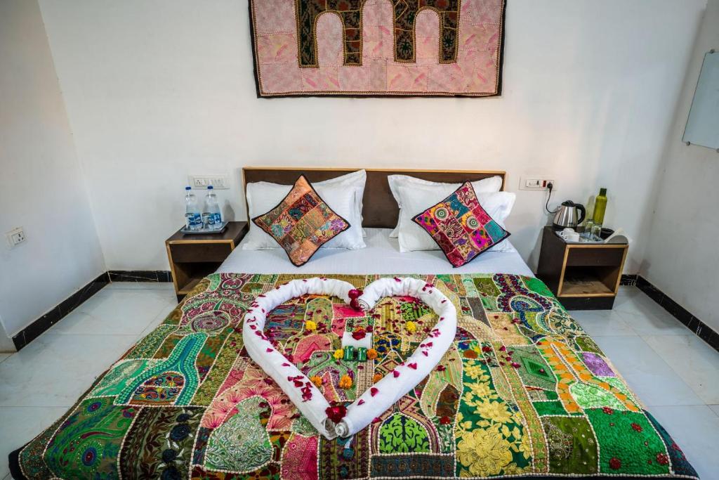 a bed with a heart made out of pillows at Rose Merry Guesthouse in Bikaner