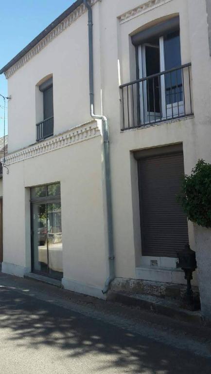 - un bâtiment blanc avec deux portes de garage et une fenêtre dans l'établissement Ouzouer le marché 6 pers Gite des barbiers, à Ouzouer-le-Marché