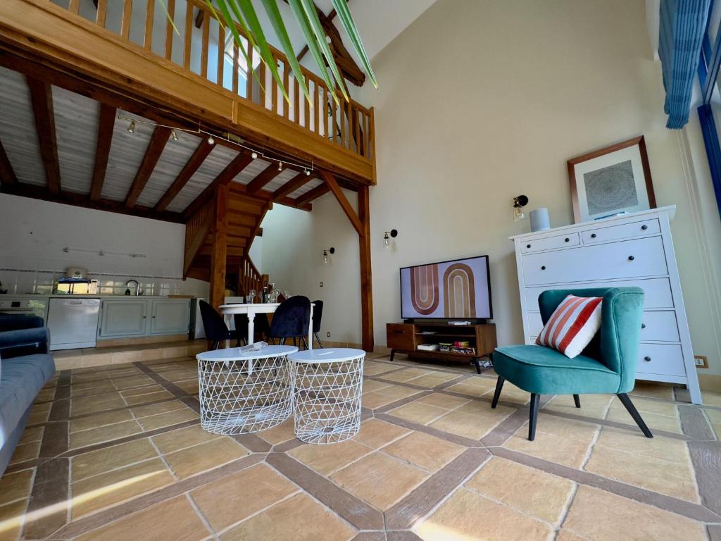 un salon avec un canapé, des chaises et une table dans l'établissement la Maison sous les Arbres - Duplex, jardin et spa, à Pocé-sur-Cisse