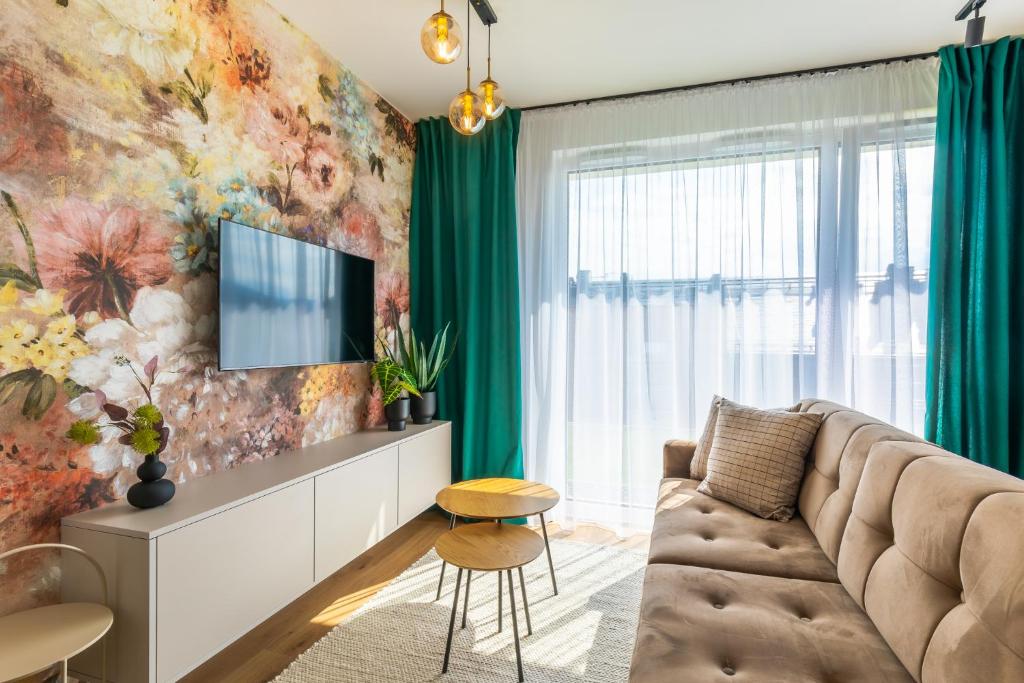 a living room with a couch and a tv at RentPlanet - Apartamenty IzerSKI Resort in Świeradów-Zdrój