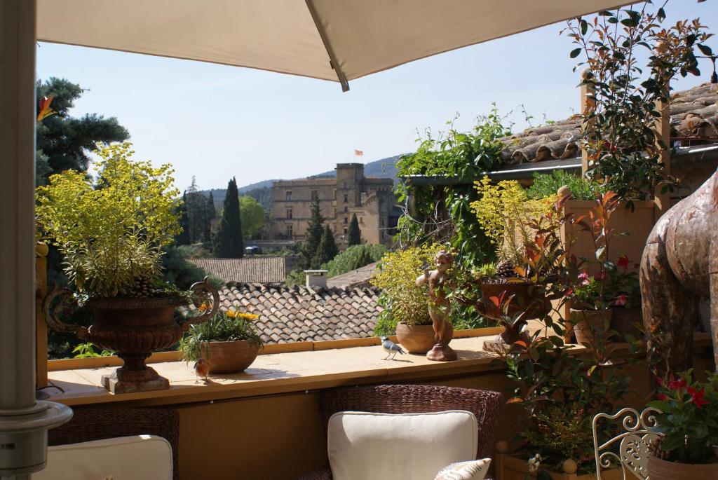 un balcon rempli de nombreuses plantes en pot dans l'établissement La BARBELLA, à Lourmarin