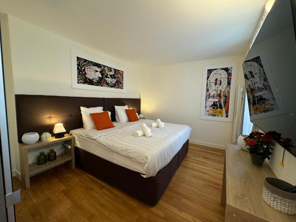 une chambre avec un grand lit avec des oreillers orange dans l'établissement Marais, Sainte-croix Bretonnerie - 6 places, à Paris