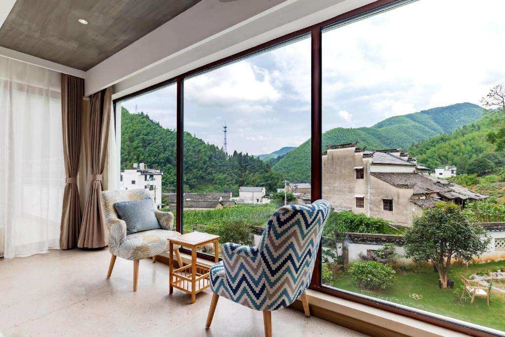 un soggiorno con una grande finestra con vista di 问安民宿（黄山风景区店） a Mount Huangshan