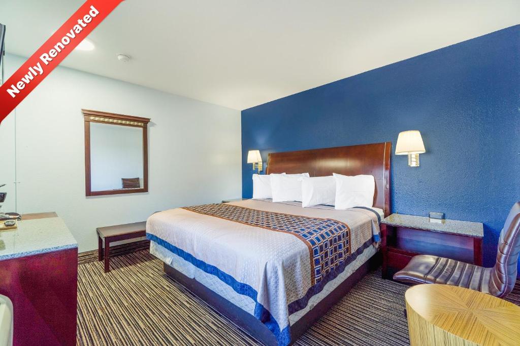 a hotel room with a large bed and a table at Budget Inn Frederick US-183 in Frederick