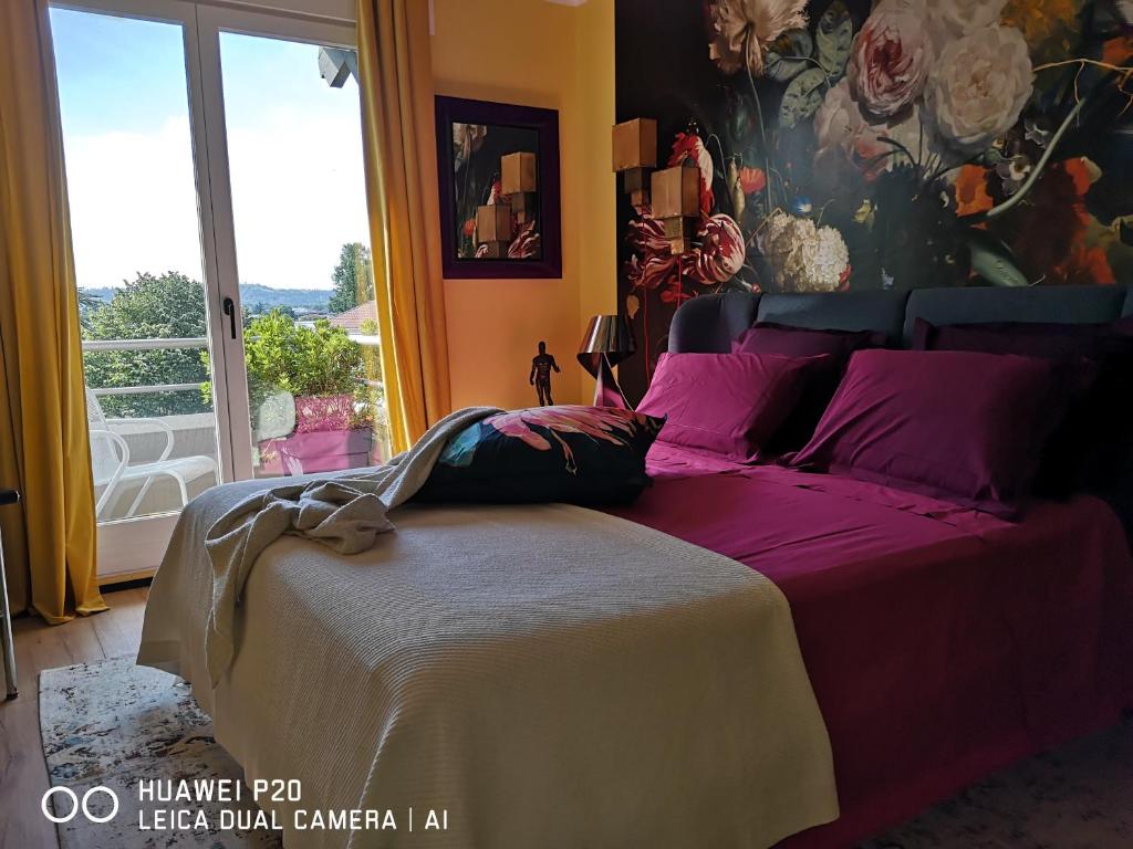 a bedroom with a bed with purple sheets and a window at La Chambre de PAT in Toulouse