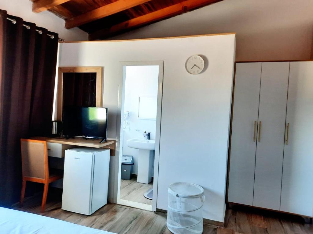 a bedroom with a bed and a desk with a clock at Apartments Alavana in Velipojë
