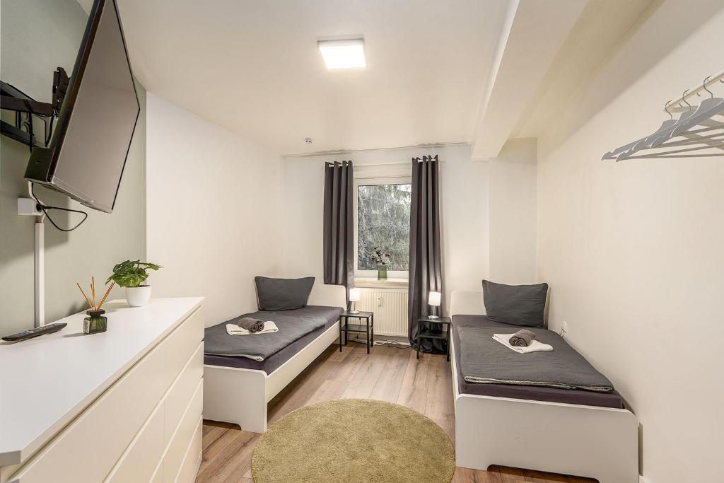 a living room with two beds and a tv at Work & Stay Apartment in Gelsenkirchen in Gelsenkirchen