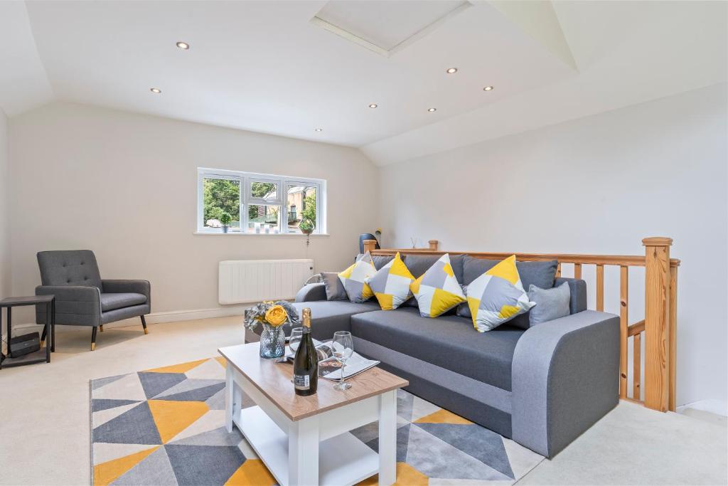 a living room with a blue couch and a table at Redhill Hideaway Stylish Spacious Apartment in Redhill