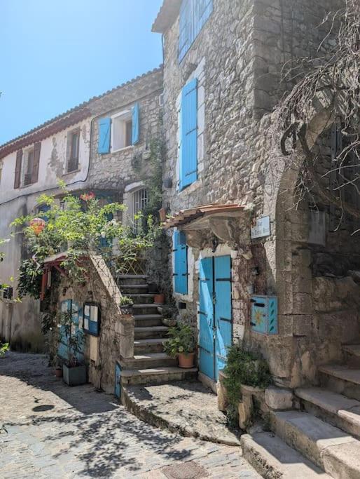 - un vieux bâtiment en pierre avec des portes et des escaliers bleus dans l'établissement La maison des couleurs, à Sauve