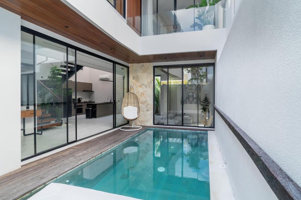 einen Innenpool in einem Haus mit Fenstern in der Unterkunft Luxury Haven Stunning 2Br in Umalas Canggu in Kerobokan