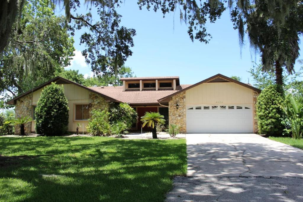 a house with a driveway and a garage at 3 Bed 2 Bath Amazing Lakeview , Jacuzzi Bath Tub in Oviedo