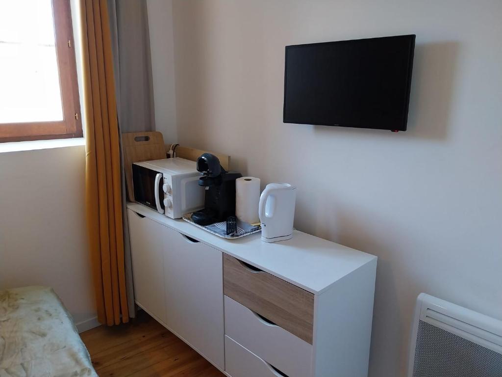 tavolo bianco con forno a microonde e TV a parete di La Treille a Saint-Thibéry