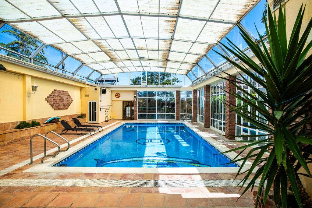 une piscine intérieure avec un plafond en verre dans l'établissement Espacio de paz, ideal para familias Villa Amalia, à Llacuna