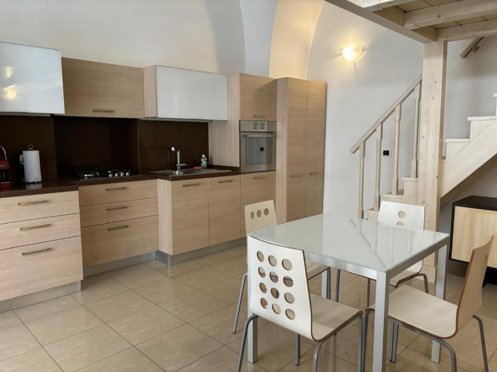 une cuisine avec une table et des chaises ainsi qu'un escalier dans l'établissement Appartamento Corso Diaz, à Sannicandro di Bari