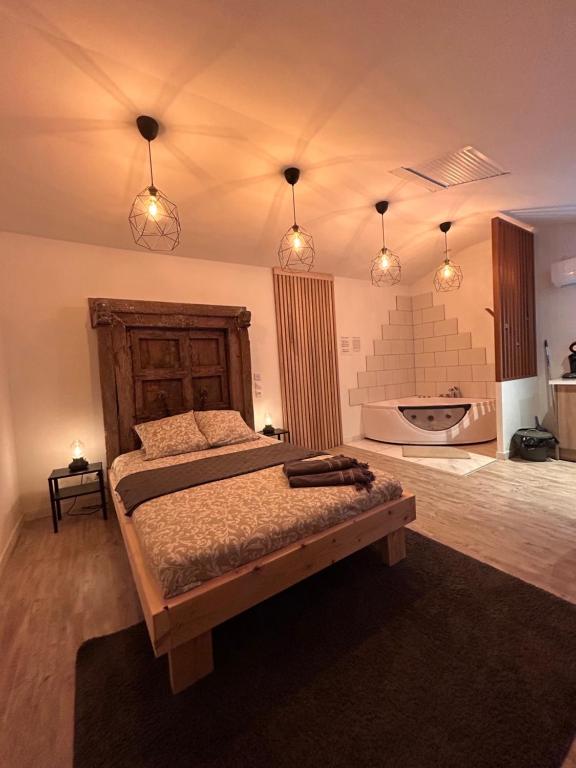 - une chambre avec un lit doté d'une tête de lit en bois et de lumières dans l'établissement Horizon Balneo, à Les Préaux