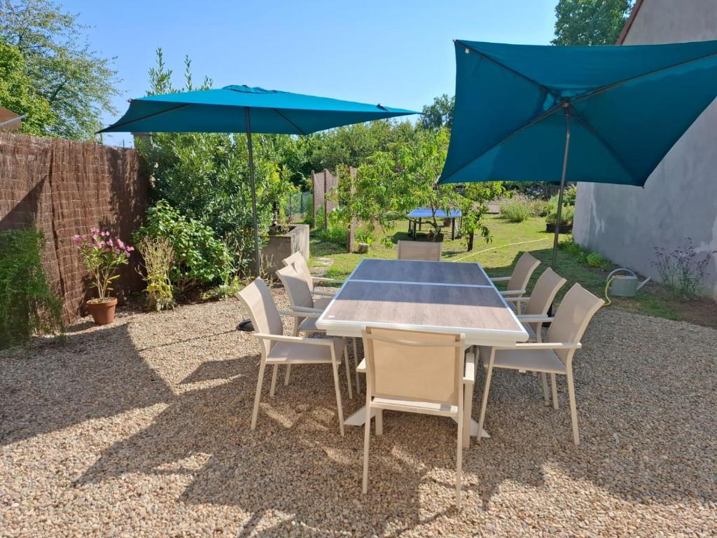 a table and chairs with umbrellas on a patio at Gîte de l'Engièvre in Beaulon