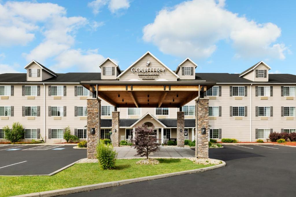an exterior view of a hotel with a large building at Country Inn & Suites by Radisson, Big Flats (Elmira), NY in Horseheads