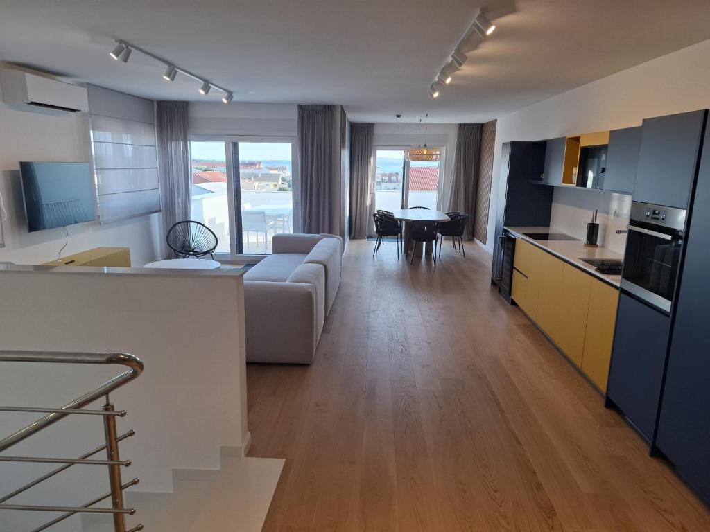 a kitchen and living room with a couch and a table at Apartman Plesa in Povljana