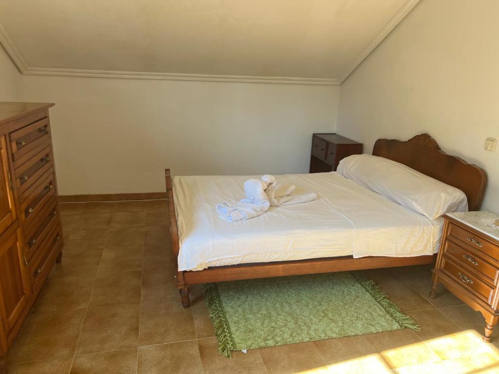 a bedroom with a bed with a teddy bear on it at Pensión montoxo in Cedeira