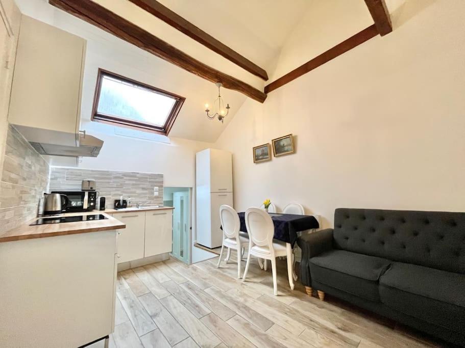 Il dispose d'une cuisine et d'un salon avec un canapé et une table. dans l'établissement Chic 3 pièces Massy centre proche Paris, à Massy