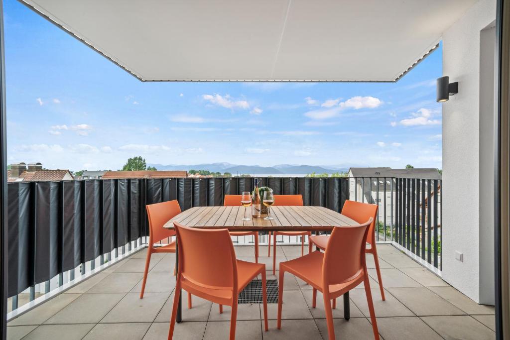 eine Terrasse mit Tisch und Stühlen auf einem Balkon in der Unterkunft Heimathafen mit See- & Bergsicht in Friedrichshafen