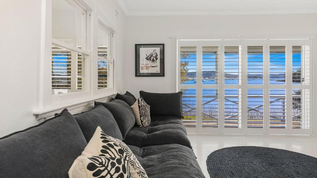 ein Wohnzimmer mit einer Couch und zwei Fenstern in der Unterkunft 'Yaringaa' by HolidayCo in Hardys Bay