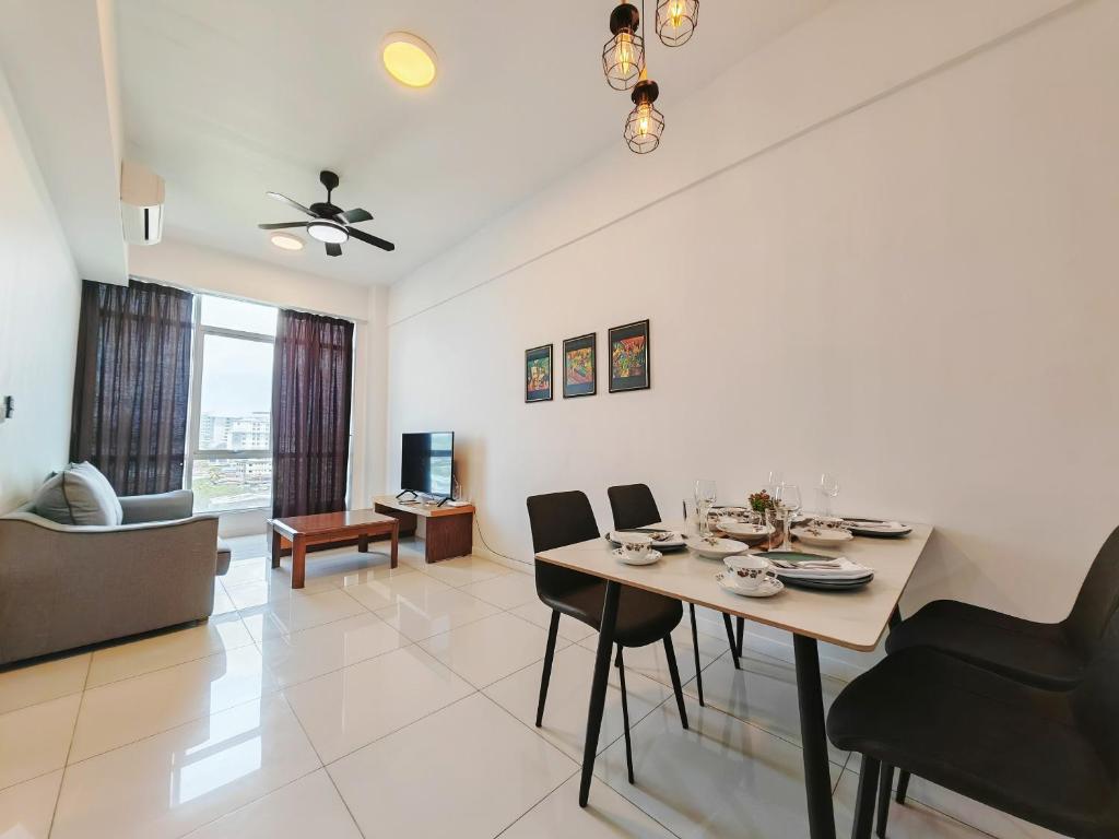 a dining room and living room with a table and chairs at Sutera Avenue Rooftop Infinity Pool KK Infini Stay in Kota Kinabalu