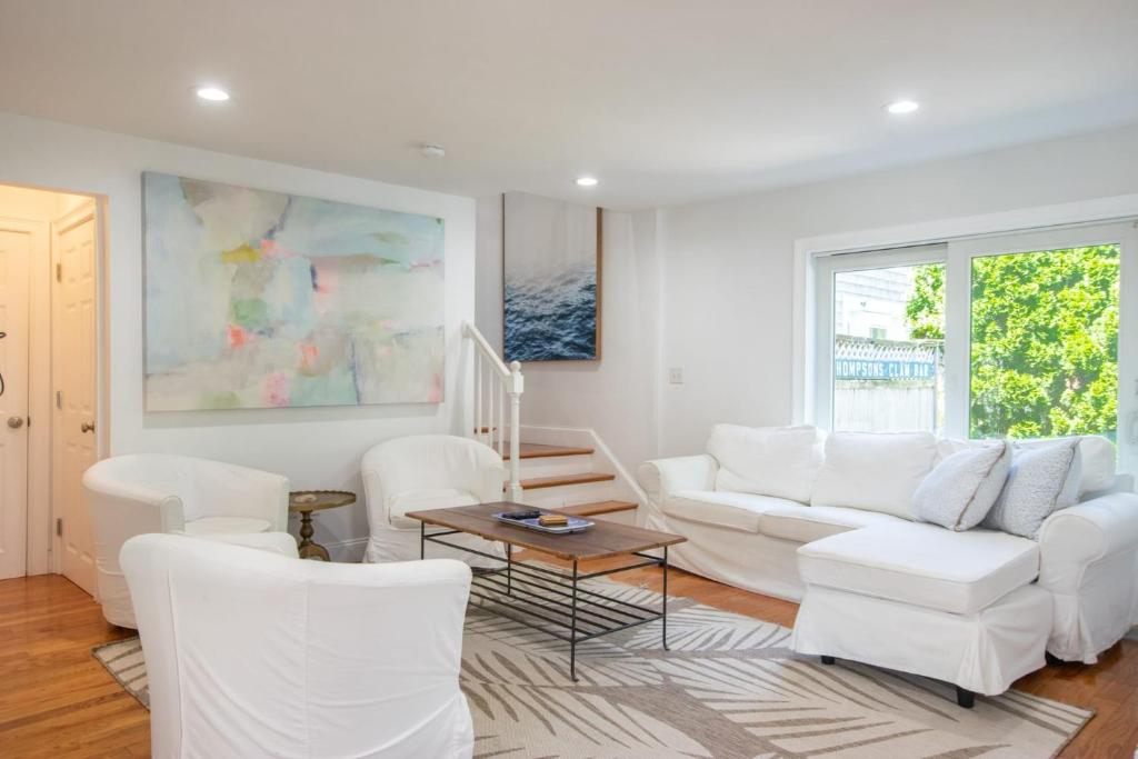 a living room with white furniture and a large window at Walk 0 3 Mile to Bank Street Beach in Harwich