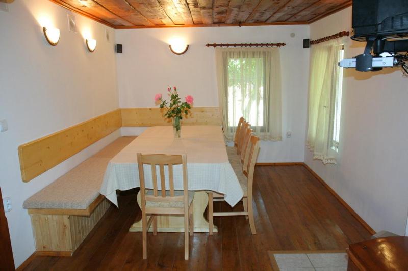 un comedor con mesa y sillas en una habitación en Lazarovata House, en Rebrevtsi