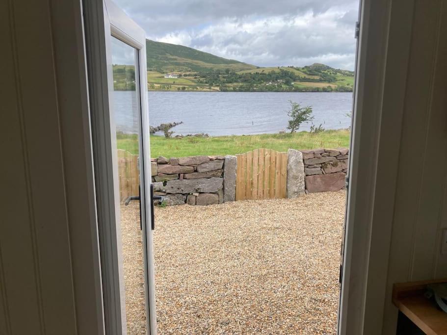 an open door with a view of a body of water at Lakeside Cabin in Galway