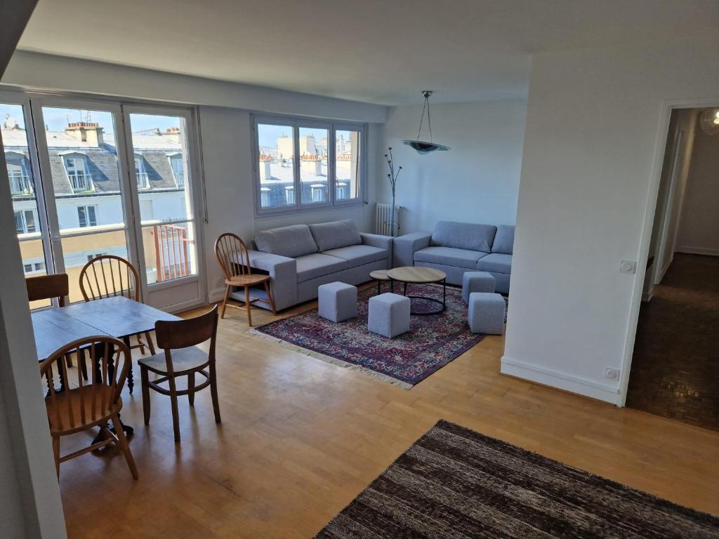 un salon avec un canapé et une table dans l'établissement Grand Appartement Parisien Lumineux Nation 3 chambres Etage élevé, à Paris