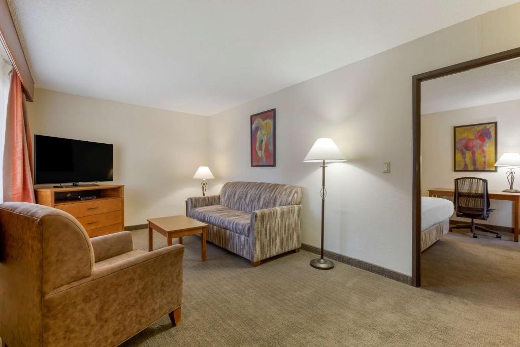 a living room with a couch a chair and a television at Best Western Paint Pony Lodge in Show Low