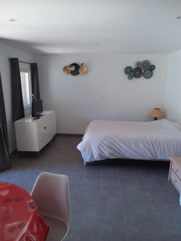 une chambre avec un lit, une table et une chaise dans l'établissement Meublé avec cour, à Sotteville-lès-Rouen