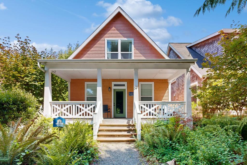 a red house with a white porch and stairs at Bella Beach Home in Depoe Bay