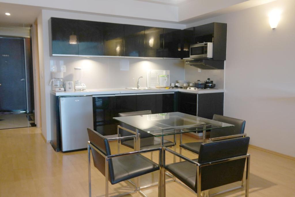 A suite kitchenette combines black cabinetry, basic appliances, and a four-seat dining table.
