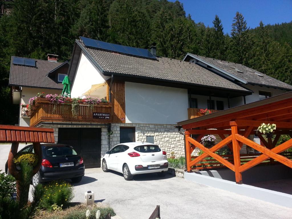 un coche blanco estacionado frente a una casa en Apartments Oman, en Kranjska Gora