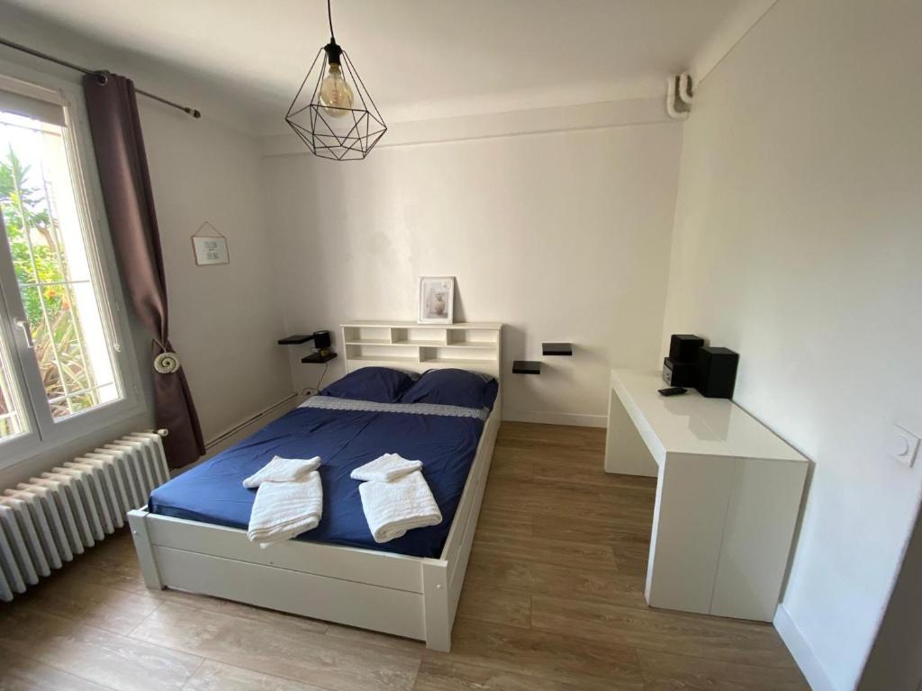 une petite chambre avec un lit et un bureau dans l'établissement La campagne en ville piscine, jardins et 2 chambres tout confort, à Nice