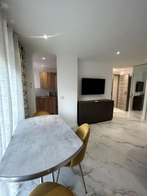une salle à manger avec une table, des chaises et une télévision dans l'établissement Superbe studio, à Vallauris