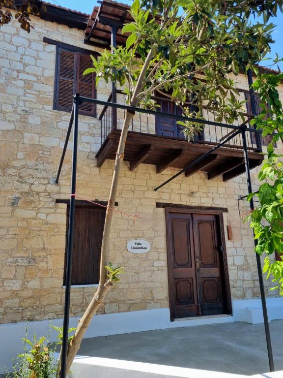a tree in front of a building with a wooden door at Villa Christothea in Paphos
