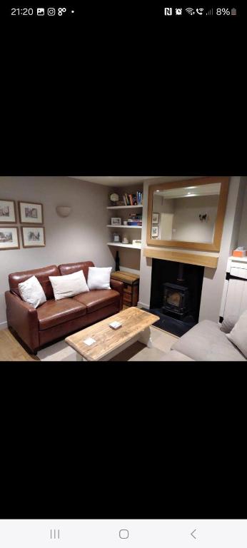 un salon avec un canapé et une cheminée dans l'établissement Kingsgate Cottage, à Winchester