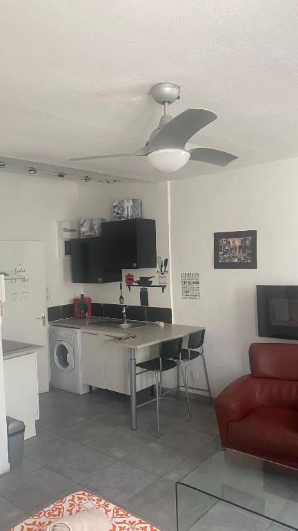 - un salon avec une table et un four micro-ondes dans l'établissement Le Suffren, studio classé ventilé ,wifi, à 100 m de la plage, à Toulon